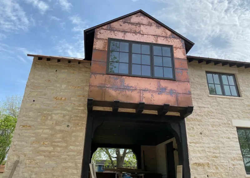 Copper metal panel facade on a stone building for Roof Repair in Timberwood Park